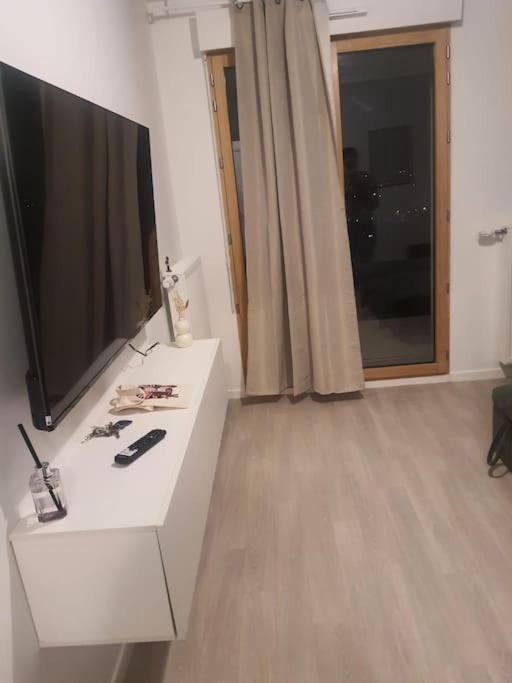 un salon avec une télévision à écran plat sur une table blanche dans l'établissement Studio équipé proche metro 14 Institut Gustave RoussyVillejuif, à Villejuif