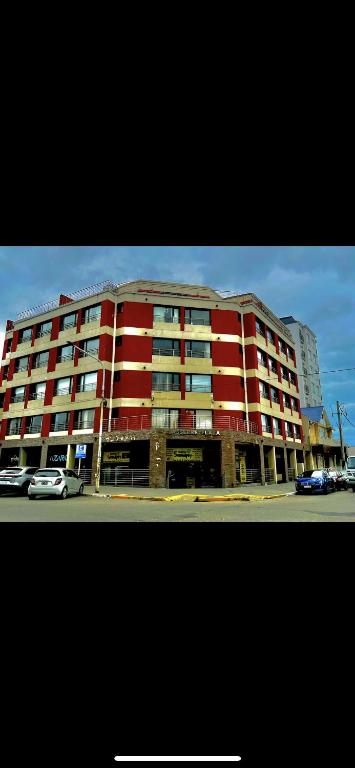 a large red building with cars parked in front of it at Alquiler en pleno centro in Río Grande