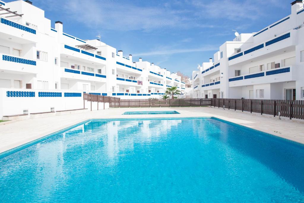 a large swimming pool in front of a building at Santos Apartment in Santa Luzia