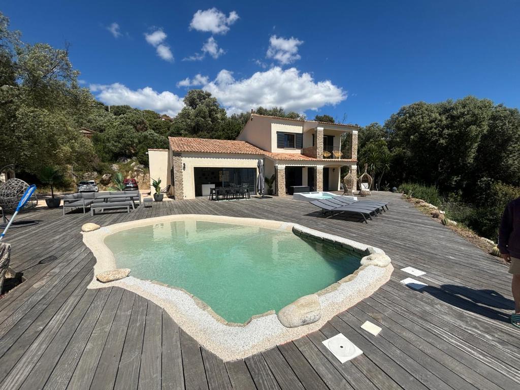 a house with a swimming pool on a wooden deck at Casa Nostra in Olmeto