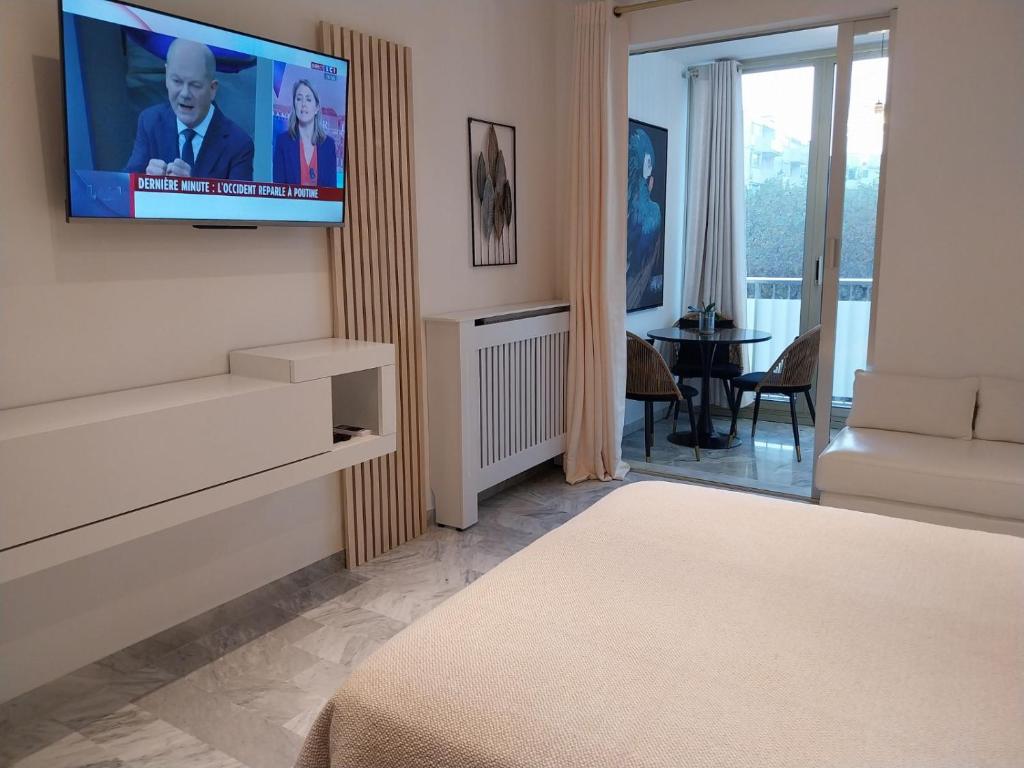 un salon avec une télévision sur un mur dans l'établissement Palm beach Cannes La Brise, à Cannes