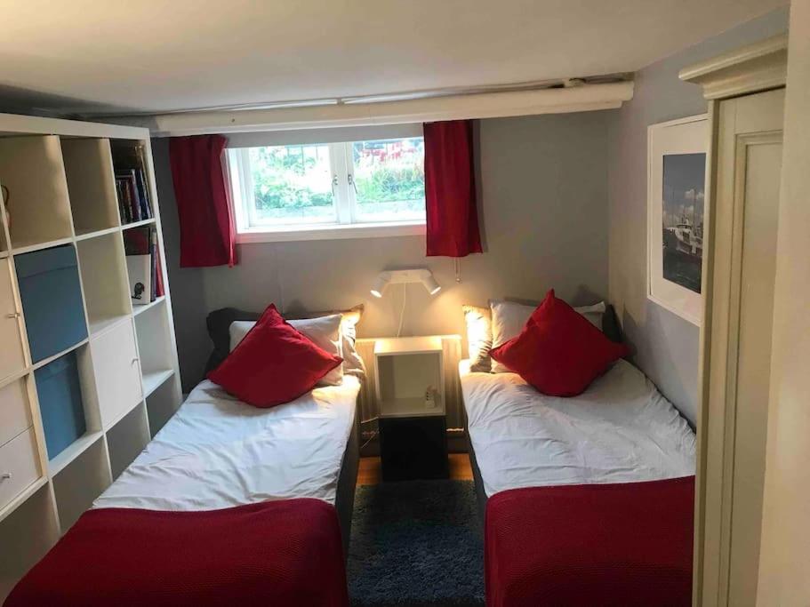エレブルーにあるCozy studio apartment near city centrumの赤い枕のベッド2台が備わる小さな客室です。