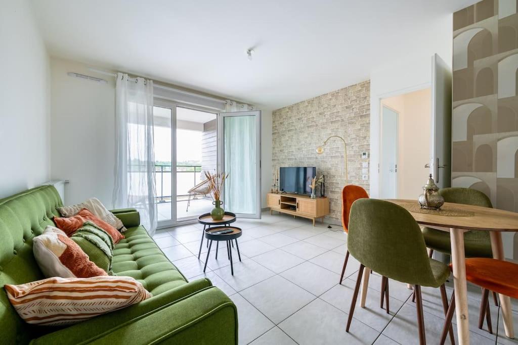 un salon avec un canapé vert et une table dans l'établissement Terrasse Parisienne - Proche Orly et Gare RER C, D, à Athis-Mons