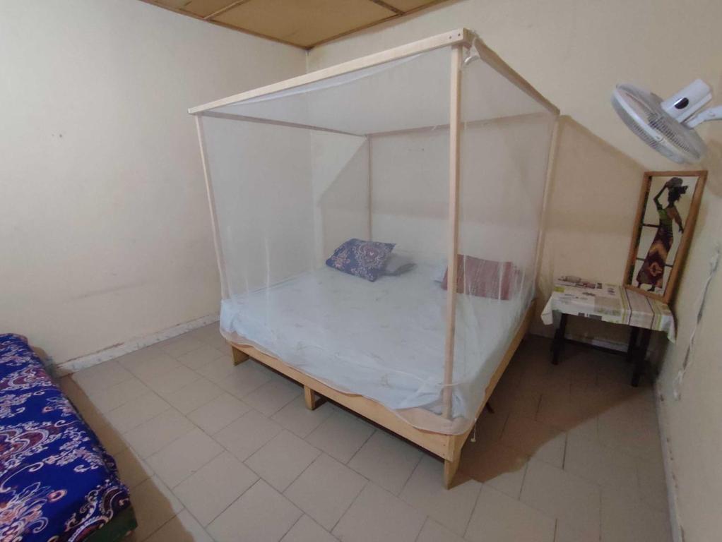un dormitorio con una cama con dosel en Keur Karim, en Niodior