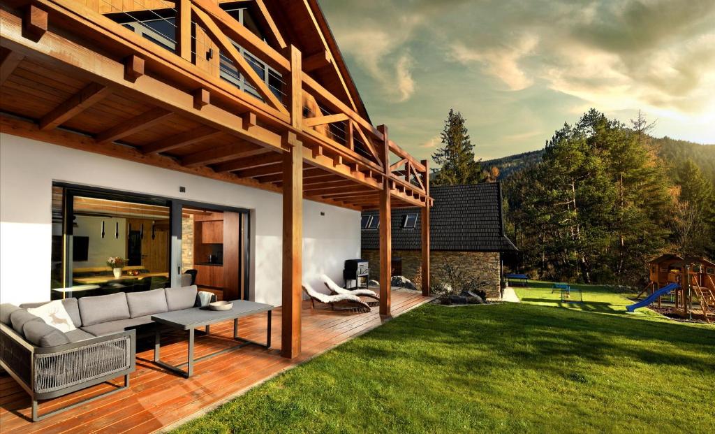 a patio with a couch and a table in a yard at Chalet Oasis - Luxury 5-Bedroom Chalet with Panoramic Views in Huty