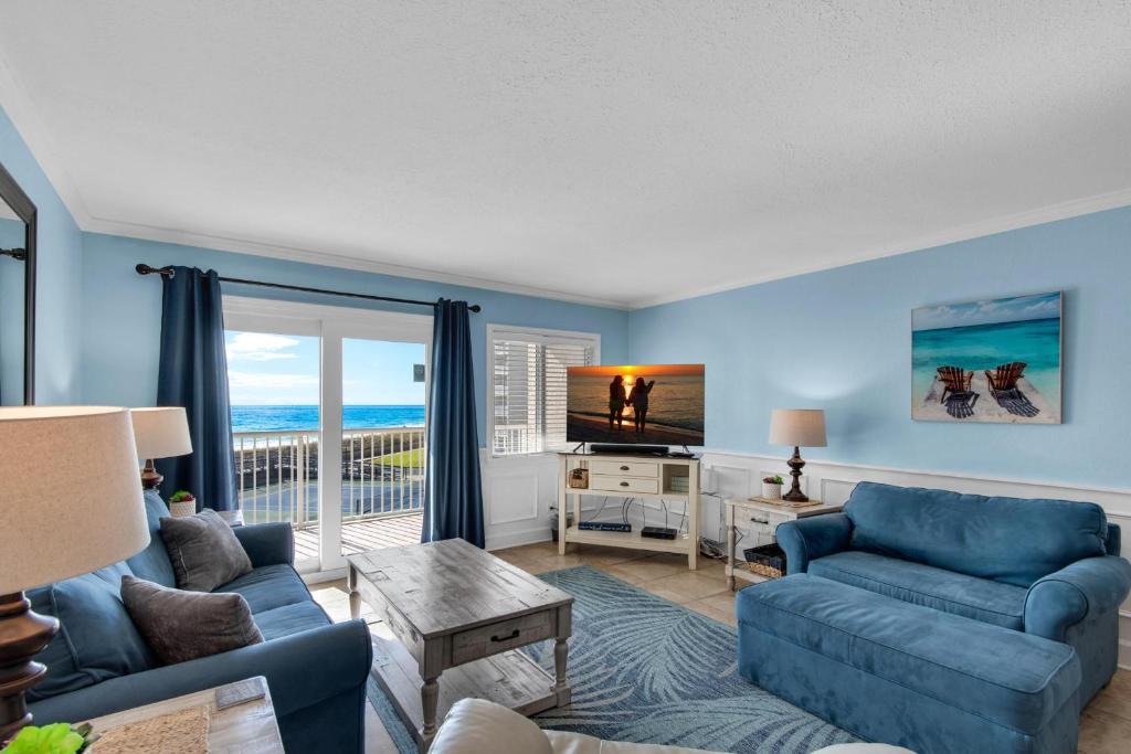 a living room with a couch and a tv at Holiday Surf and Racquet Club 319 in Destin