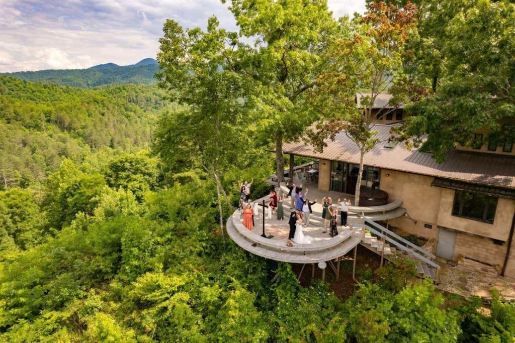 un gruppo di persone che si trovano fuori da un edificio nel bosco di EagleWatch Mountain Retreat & Event Venue a Bryson City