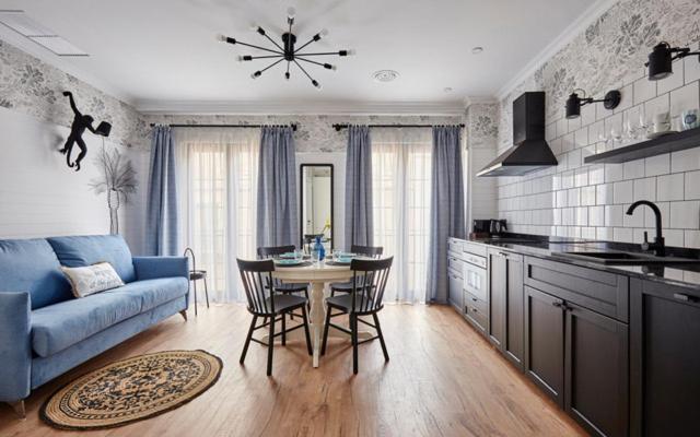 a kitchen with a blue couch and a table and chairs at Parrot’s House in Lloret de Mar