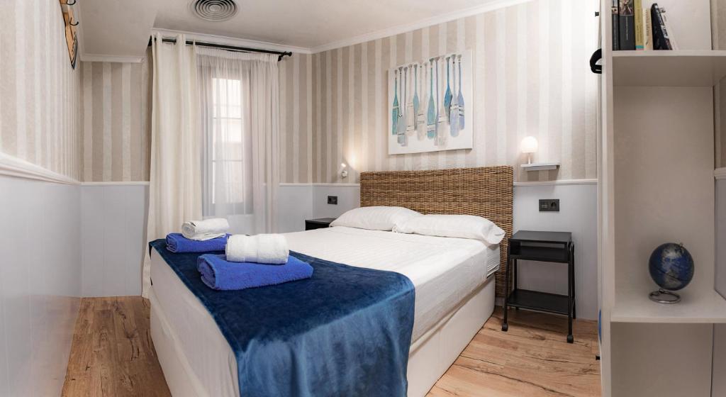 a bedroom with a bed with two towels on it at Parrot’s House in Lloret de Mar