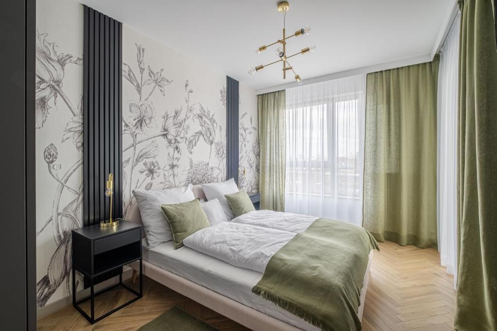Hotel Stocznia Apartments, a bedroom with a bed and a chandelier at Stocznia Apartments in Gdańsk