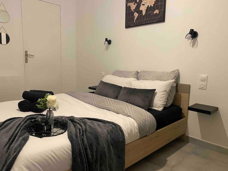 - une chambre avec 2 lits et un vase fleuri dans l'établissement Logement entier 3P proche centre ville, à Saint-Quentin