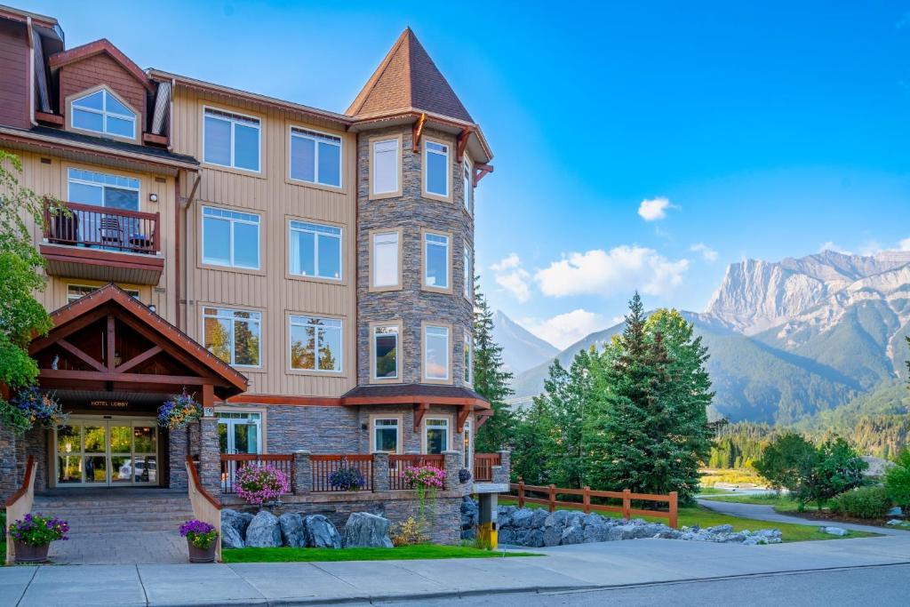 坎莫尔集团猎鹰峰山林小屋酒店的一座大建筑,背景是群山