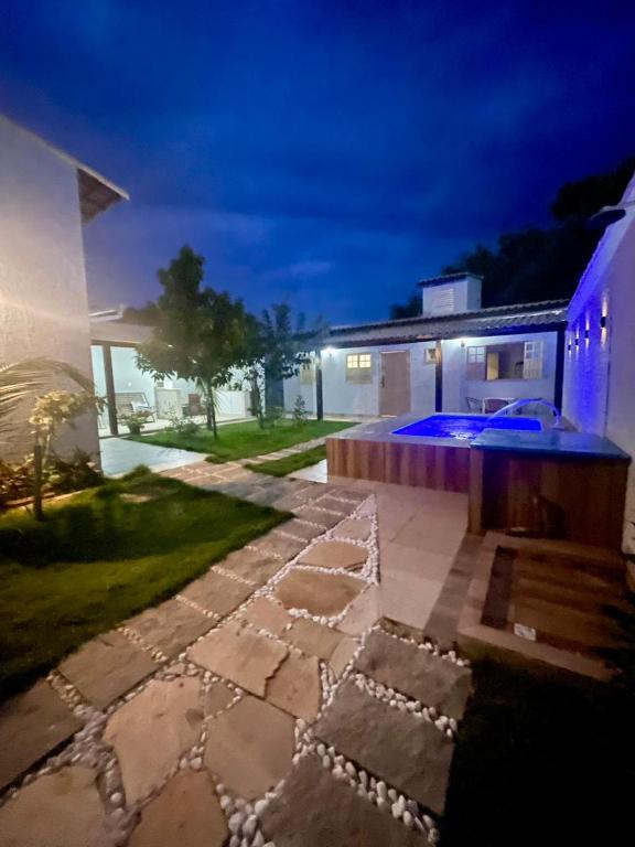 a backyard with a stone walkway in front of a house at Sweet House Búzios in Búzios