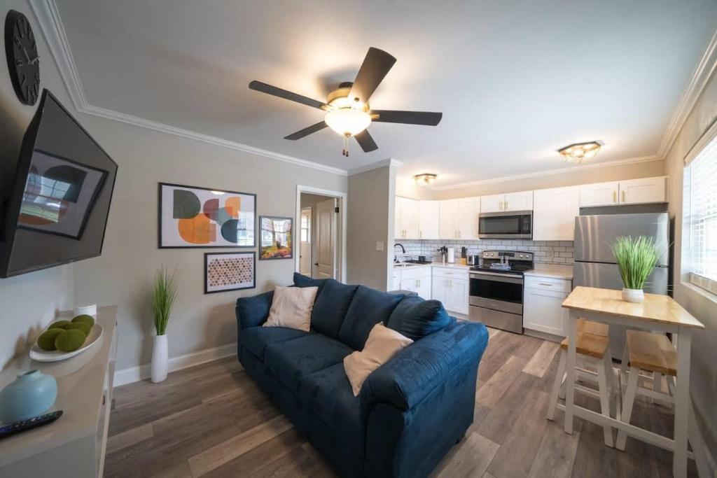 a living room with a blue couch and a ceiling fan at OV Mosaic - Float Suite in North Camellia Acres