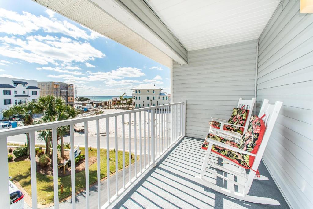 a white rocking chair on a balcony with a view of the ocean at Beachside Villas 332 in Santa Rosa Beach