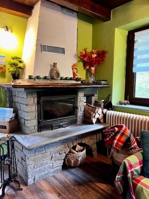 a living room with a stone fireplace and a couch at Maison Ama Charvensod in Charvensod