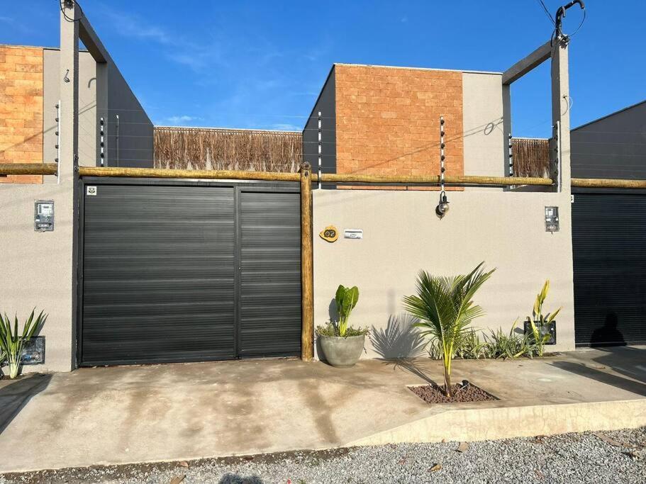 a garage with black doors on the side of a house at Casa Villa Bali in Marechal Deodoro