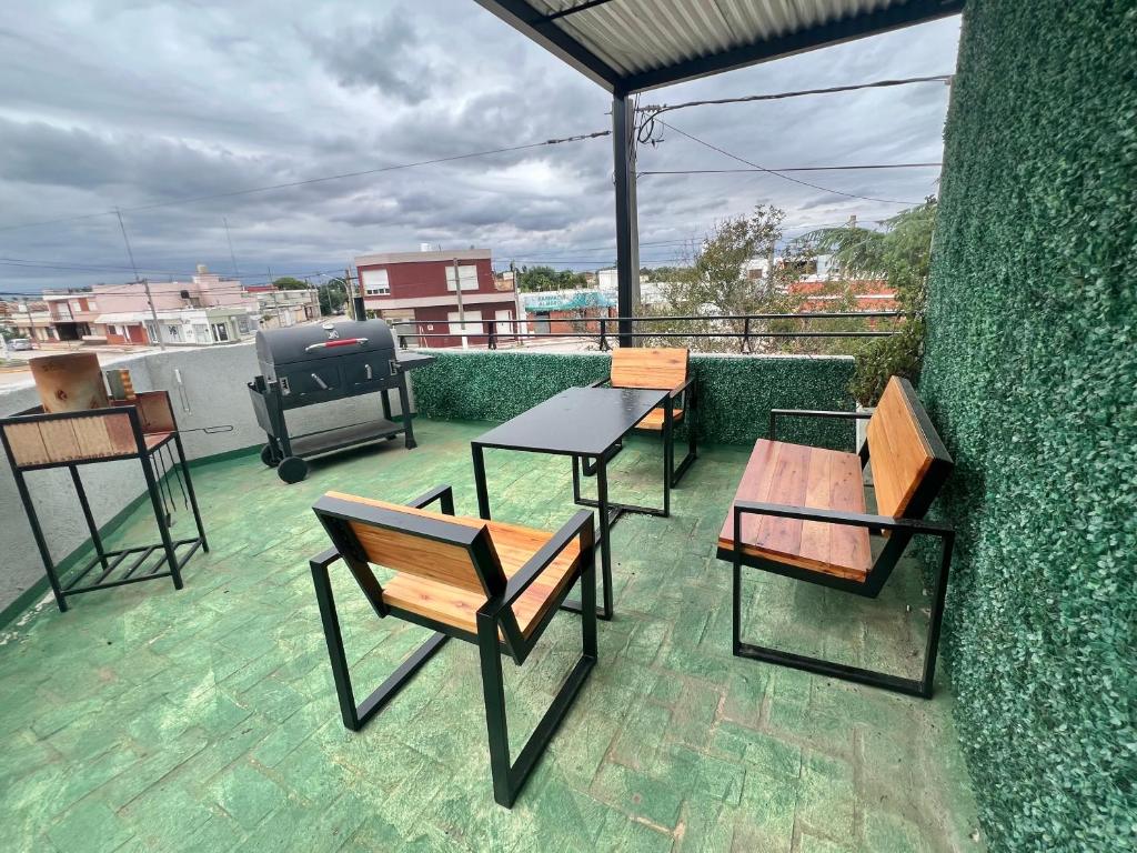 a patio with tables and chairs on a roof at Depto Siria in Almafuerte