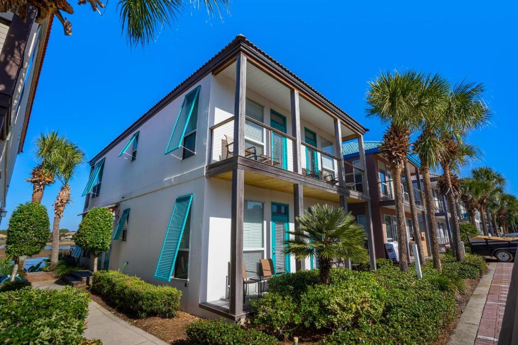 ein weißes Gebäude mit Palmen davor in der Unterkunft Destiny Beach Villas #20A in Destin