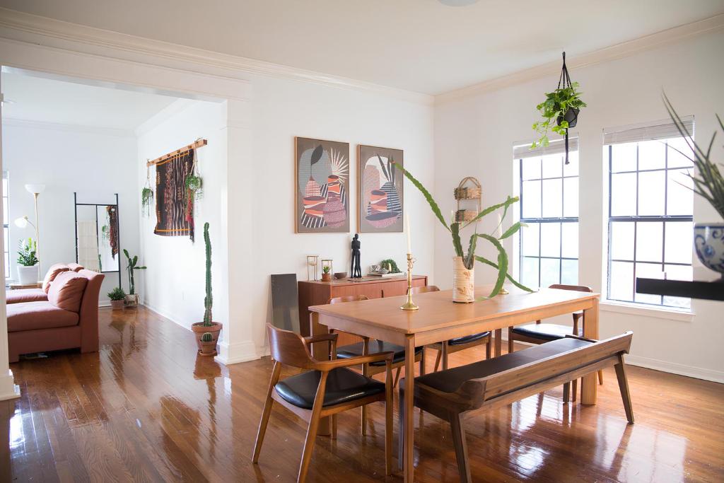 Una sala de estar con una mesa y sillas de madera. en Cozy Bohemian Bungalow, en Houston