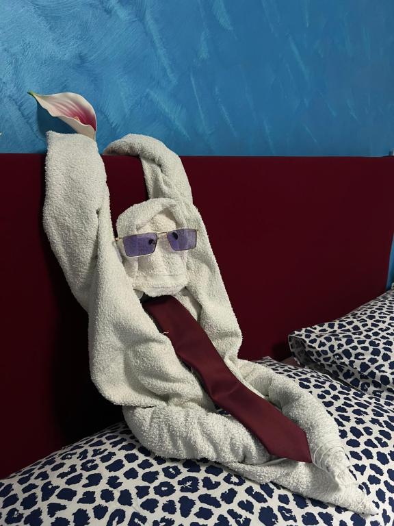 a stuffed animal with sunglasses is laying on a bed at I 7 MARI home in Salerno