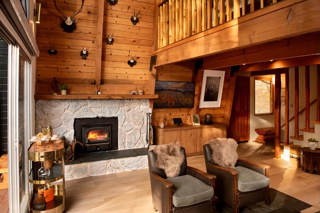 a living room with two chairs and a fireplace at Treehouse - Close to Slopes, Hot Tub, Gourmet Kitchen, Deck in Big Bear Lake