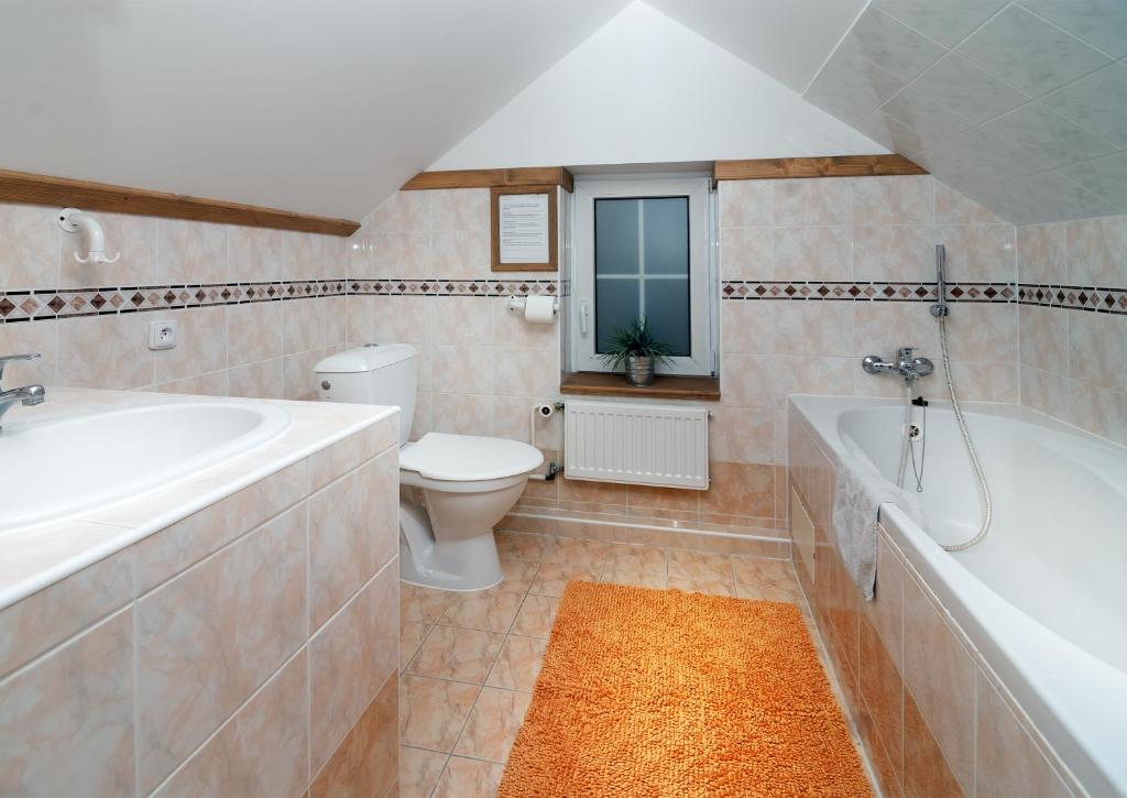 łazienka z wanną, toaletą i umywalką w obiekcie Pension and Apartments MONIKA w Szpindlerowym Młynie