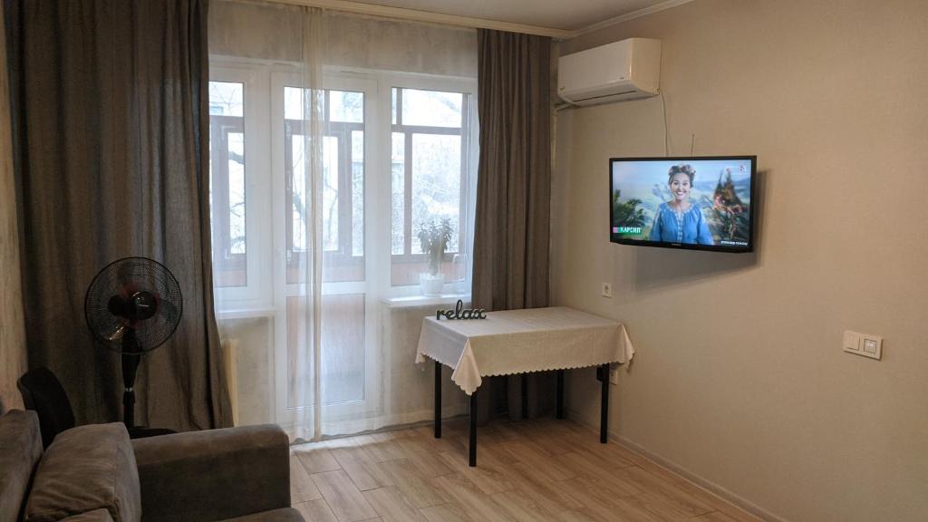 a living room with a tv hanging on the wall at Apartment near city center on Peremohy Avenue 46 in Chernihiv