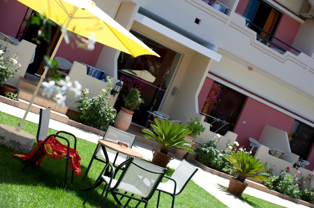a patio with chairs and a table and an umbrella at Nikolas Suites in Kato Daratso