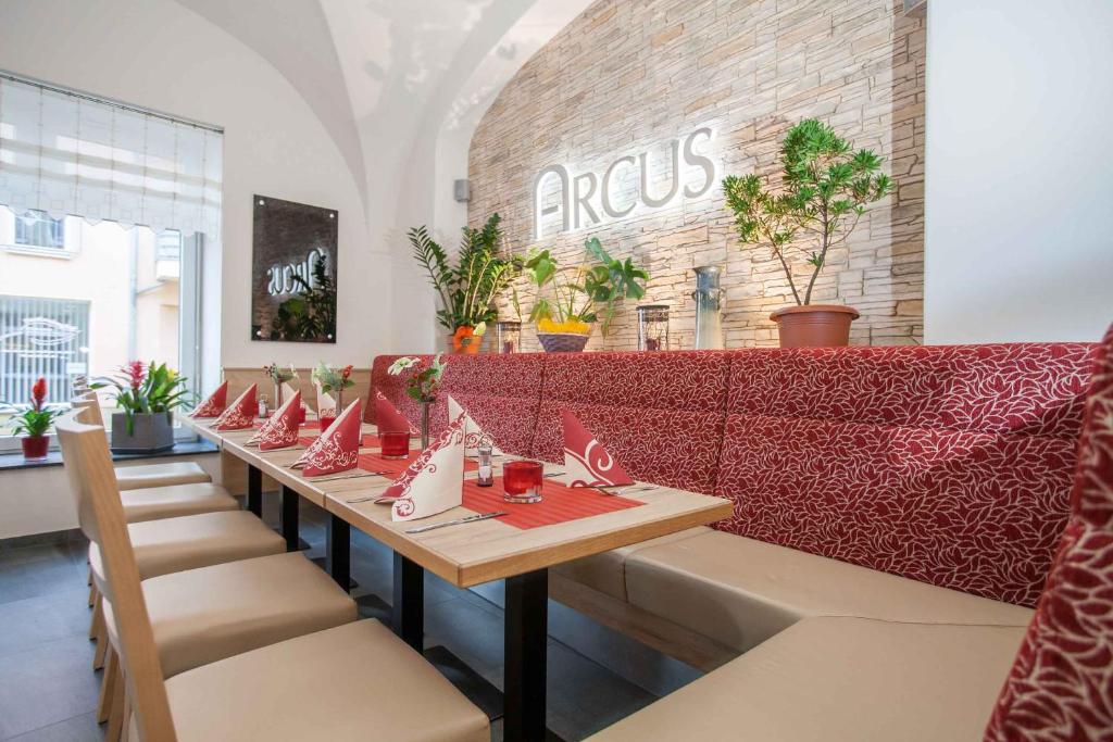 a table in a restaurant with a red couch at Hotel Arcus in Elsterwerda