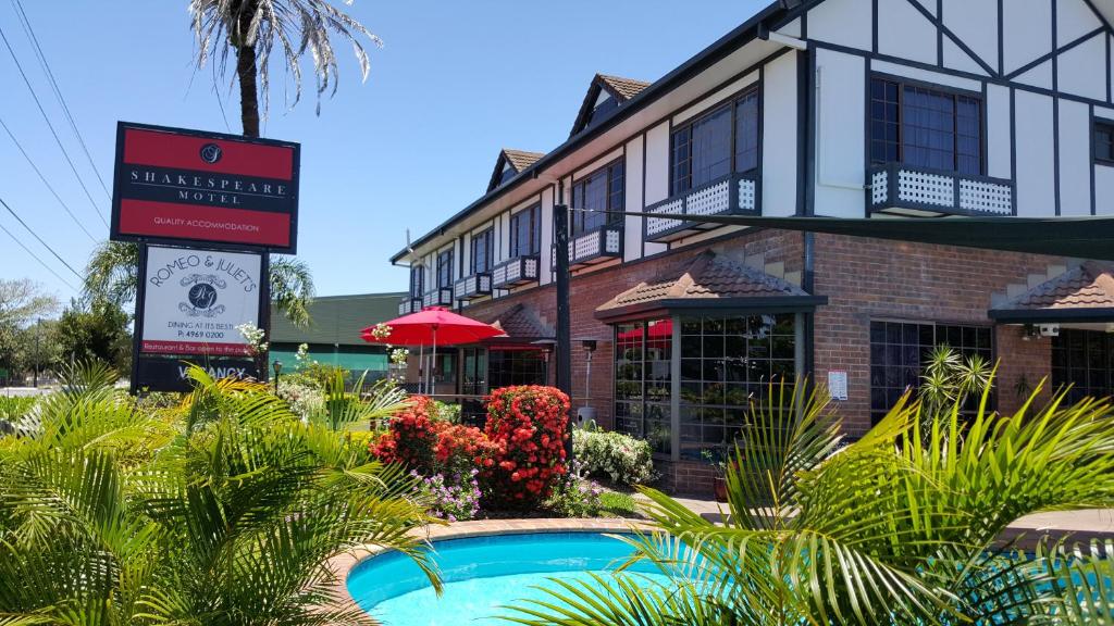 een hotel met een zwembad voor een gebouw bij Shakespeare Motel in Mackay
