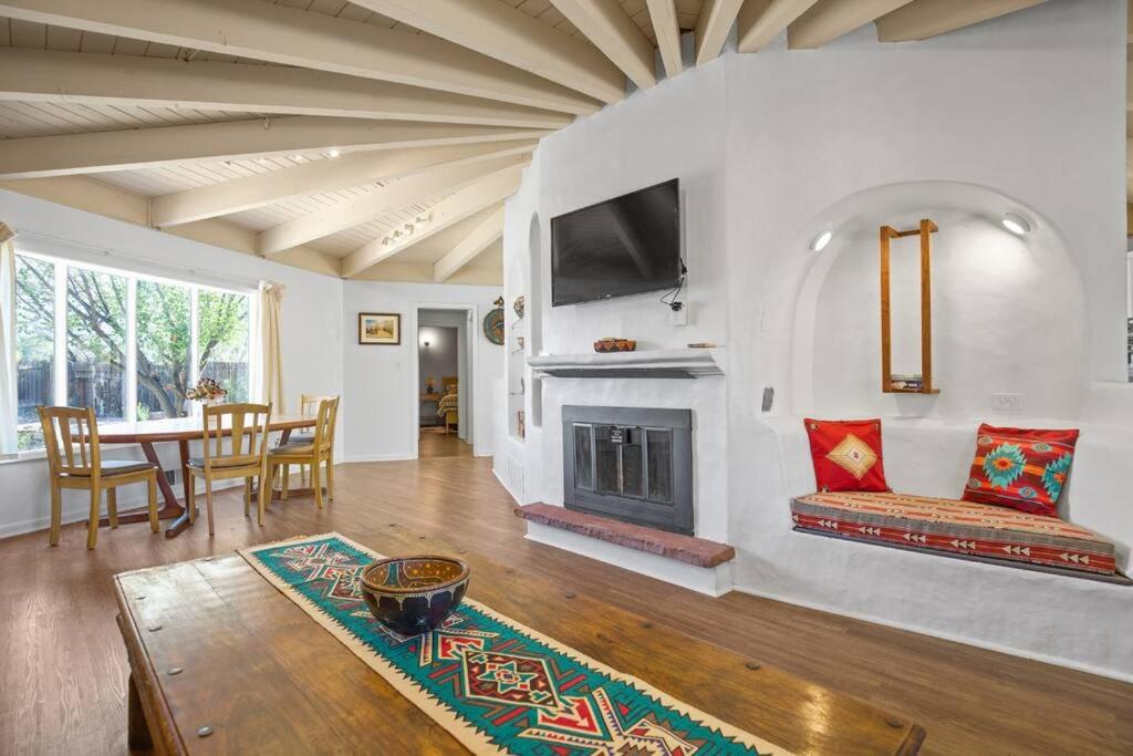 a living room with a fireplace and a table at Taos Pine Home in Taos