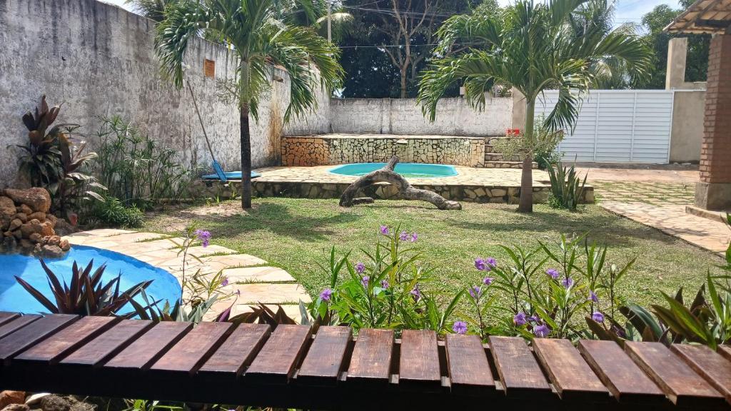 エスタンシアにあるCentro Aquatico Aratuの木製のベンチとプールのある庭園