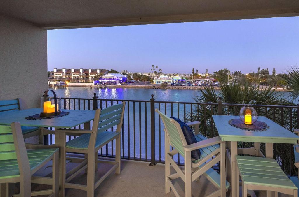 two tables and chairs on a balcony with a view of the water at Land's End 4-306 Bay Front - Premier in St Pete Beach