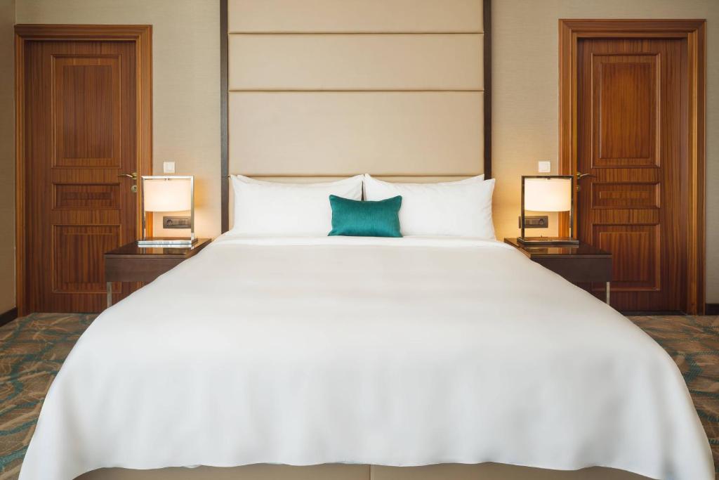 Un pat sau paturi într-o cameră la JW Marriott Bucharest Grand Hotel