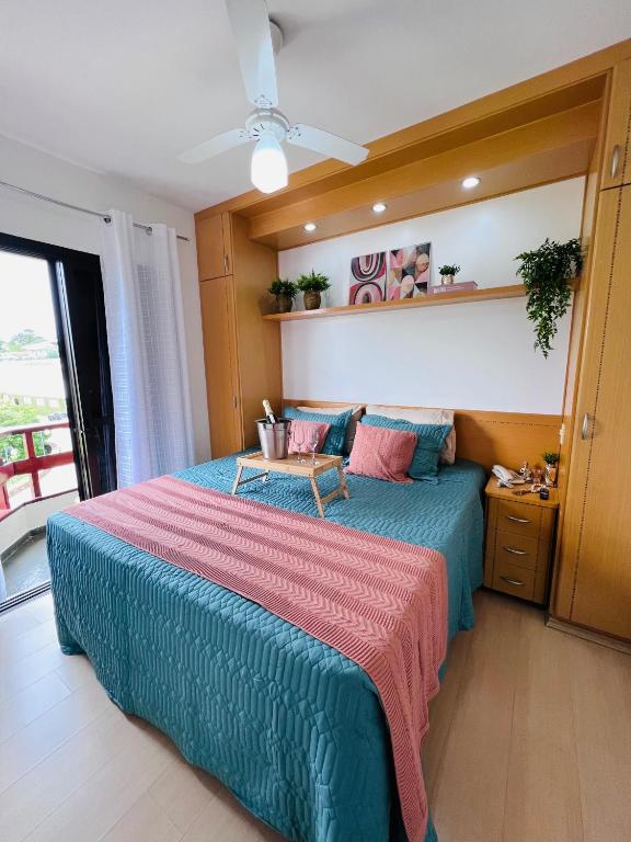 a bedroom with a large bed and a table at Flat Piemonte Apart in Serra Negra