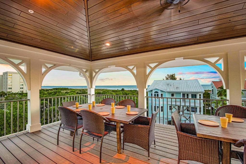 a patio with tables and chairs on a deck at Ocean Overlook in Siesta Key