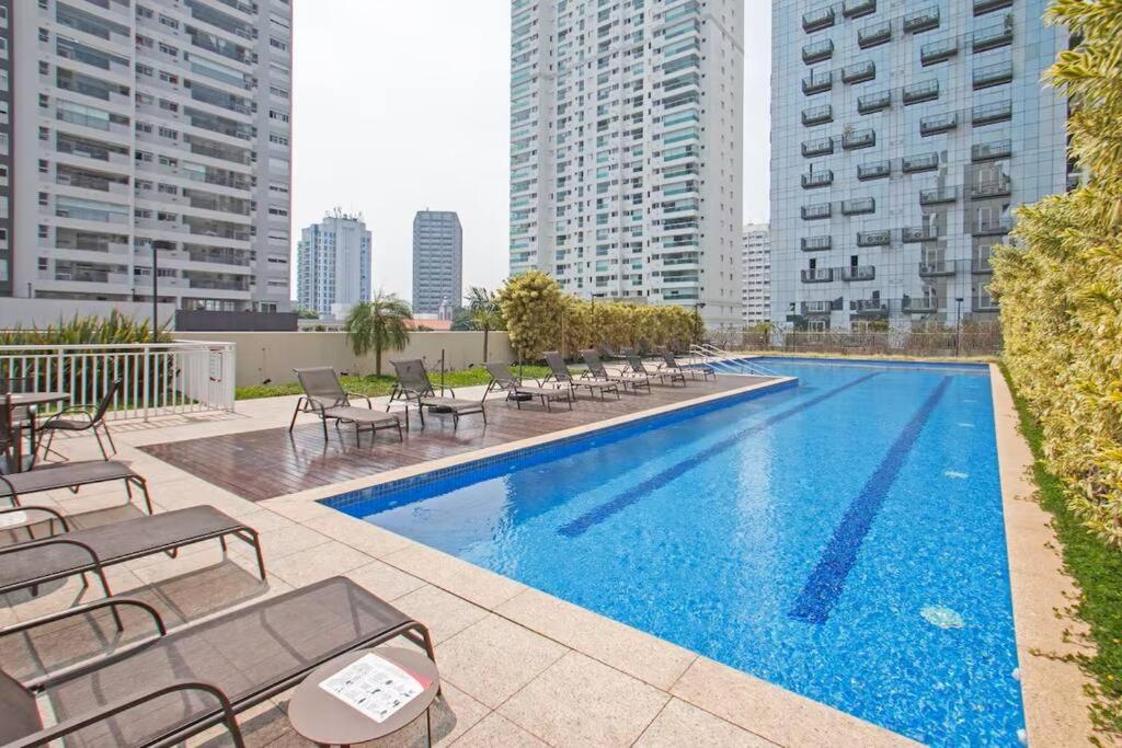 Hotel Apto novo Alto da Boa Vista - Expo Transamérica, a swimming pool with tables and chairs and buildings at Apto novo Alto da Boa Vista - Expo Transamérica in São Paulo