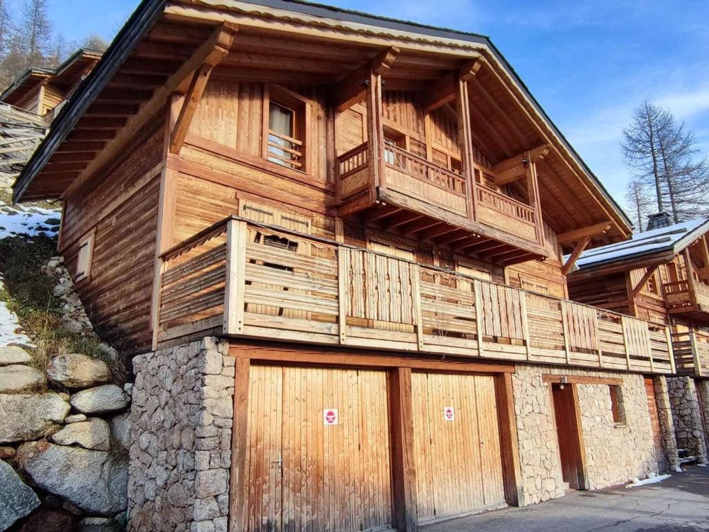 Cette maison en bois dispose d'un balcon et de deux portes de garage. dans l'établissement Chalet de luxe rénové, 5 chambres, cheminée, parking, proche Côte d'Azur - FR-1-292-219, à Isola