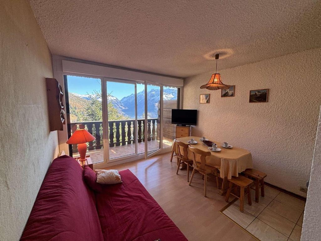 un salon avec un canapé et une table avec vue dans l'établissement Studio cabine au pied des pistes avec balcon et parking gratuit - FR-1-297-348, à Auris