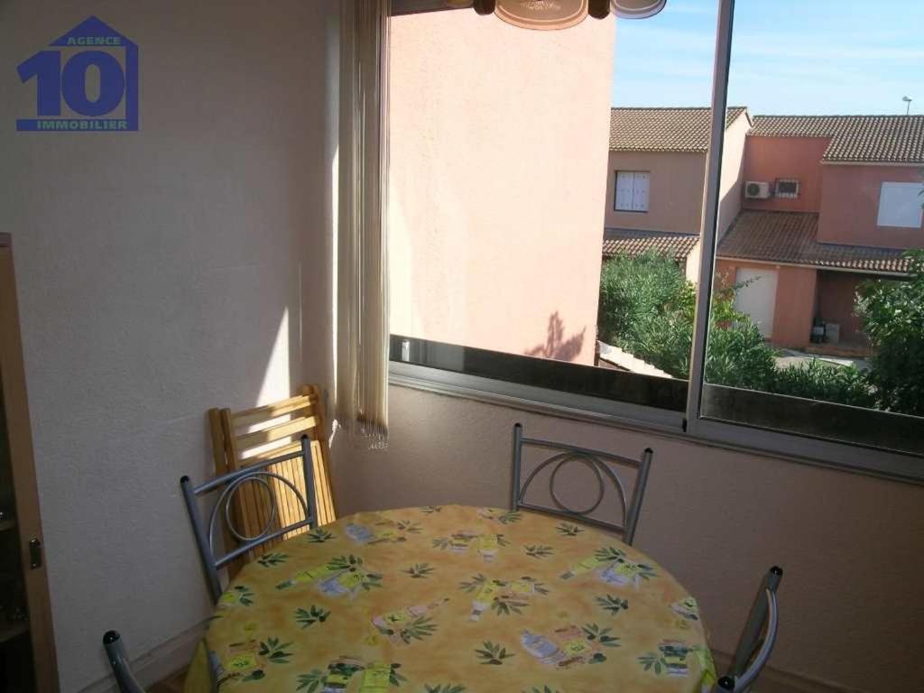 une table et des chaises dans une pièce avec une fenêtre dans l'établissement Appartement cosy 4 pers, proche plage&centre, cellier privatif - FR-1-781-65, à Valras-Plage