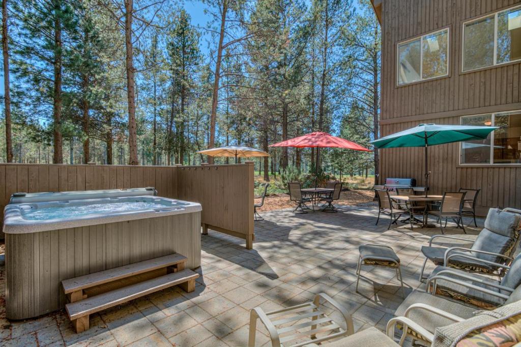 a patio with a hot tub and tables and chairs at Red Cedar - Unit 30 in Sunriver