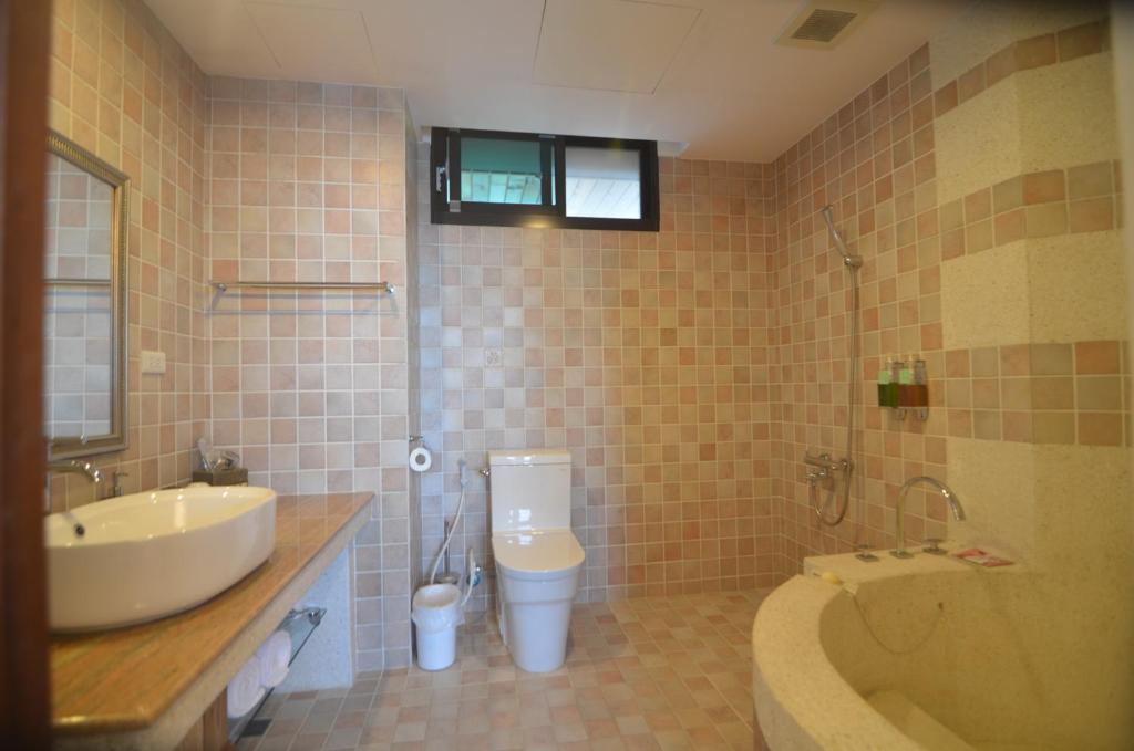 a bathroom with a sink and a toilet and a tub at Full Sweet Inn in Wujie