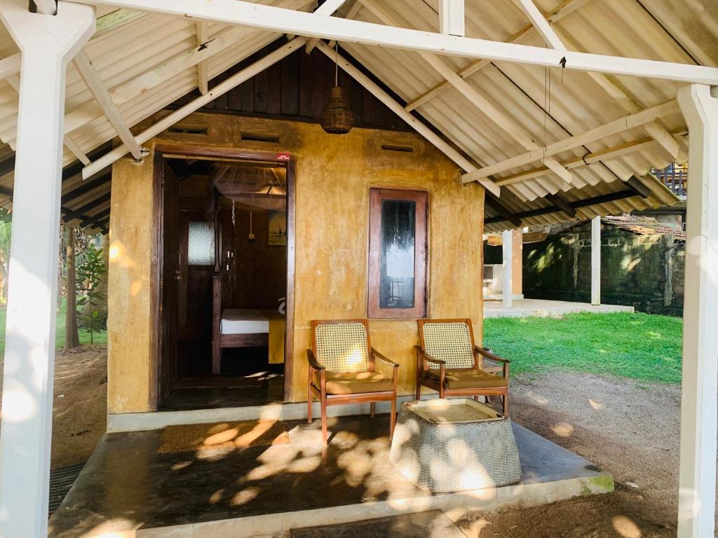 ゴールにあるSuha Beach Double Cabanaの小屋(椅子2脚、ポーチ付)