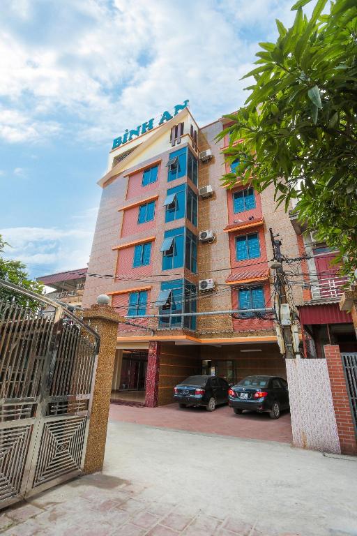 a hotel with cars parked in front of it at Khách Sạn Bình An in Sóc Sơn