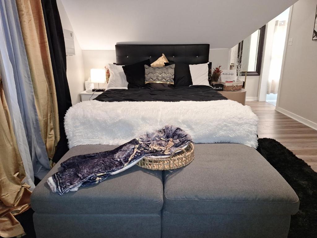 a bedroom with a bed and a ottoman with at St Paul Fry Street Den Tower Suite #3 in Saint Paul