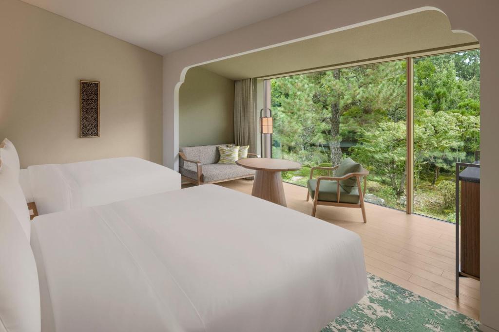 a hotel room with two beds and a balcony at Shisui, a Luxury Collection Hotel, Nara in Nara