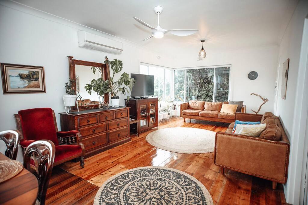 a living room with a couch and a table at Craypot Cottage in Port Campbell