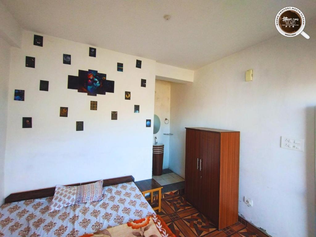 a bedroom with a bed and a wall with pictures at Hashtag95 in KumhÄrsain