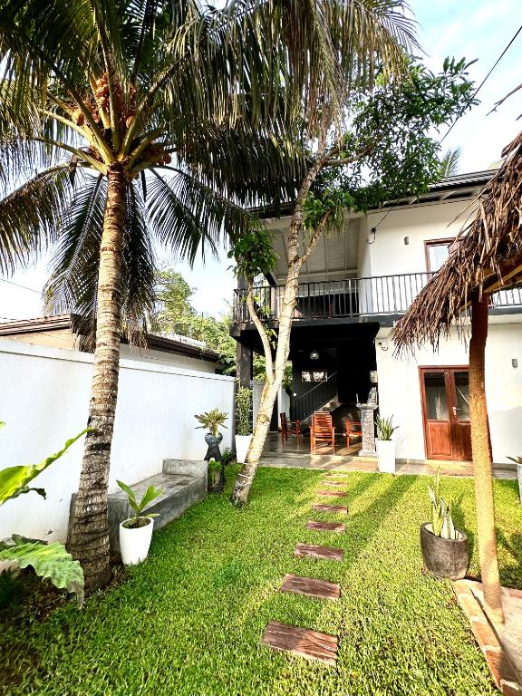 a backyard with palm trees and a house at Surf Heavens in Dickwella